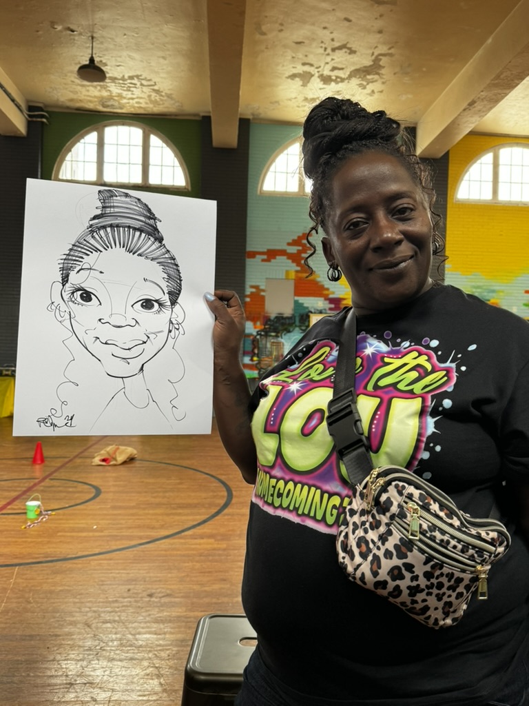 A guest holds her black-and-white caricature at a community gathering