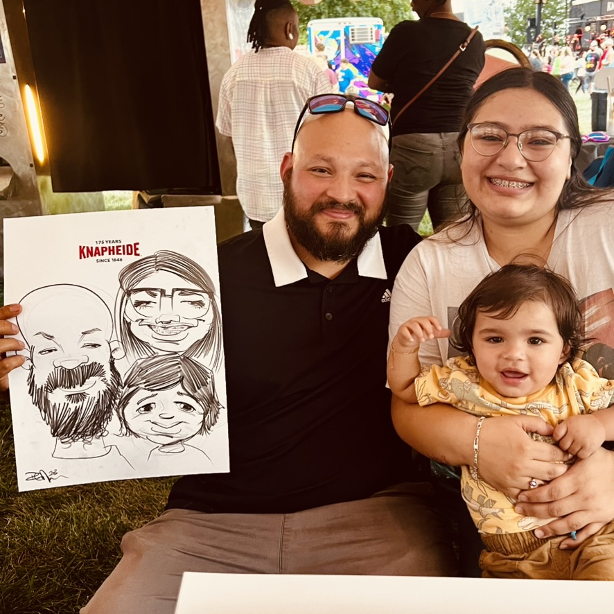 A family smiles with their black-and-white caricature at an outdoor event